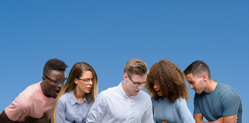 Sticker - Composition of group of friends over blue blackground with hand on stomach because nausea, painful disease feeling unwell. Ache concept.