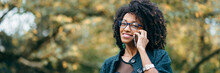 Happy Black Woman During A Mobile Phone Call In Autumn