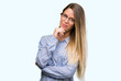 © Krakenimages.com - Beautiful young woman wearing elegant shirt and glasses looking confident at the camera with smile with crossed arms and hand raised on chin. Thinking positive.