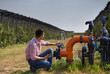 © Budimir Jevtic - Farmer with tablet beside irrigation pipes in apple orchard