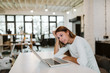 © bnenin - Young woman working in bright co-working office.