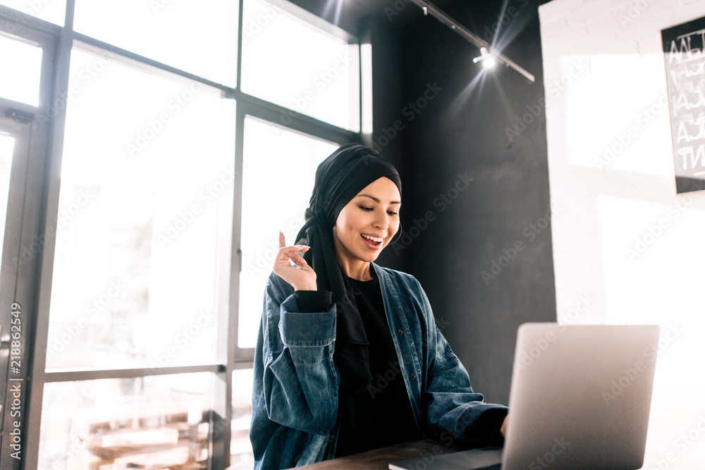 Muslim hijab girl working at laptop in office raised finger up Stock ...
