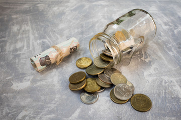 coins poured from the jar on a concrete background