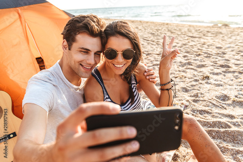 Cute Loving Couple Make Selfie By Mobile Phone On The Beach Outdoors