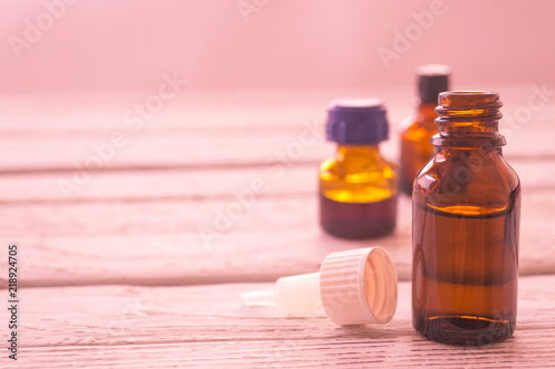 Fotografía Dark vials of medicine on a wooden table.