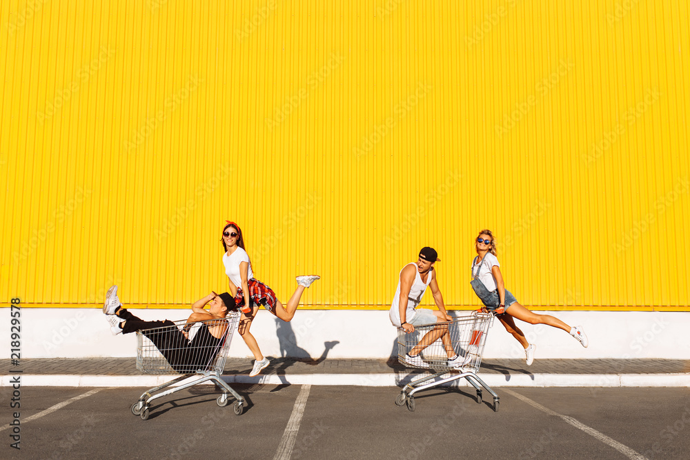 Friends ride on carts, near the supermarket, a great pastime, a group ...