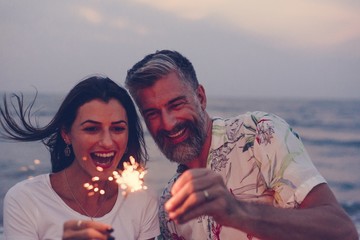 Couple celebrating with sparklers at the beach