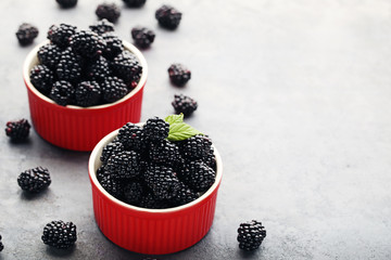 Wall Mural - Ripe and sweet blackberries in bowl on grey wooden table