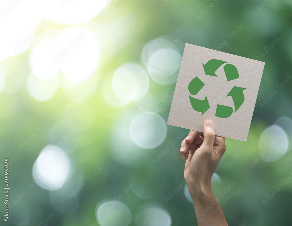 Hand holding recycle symbol on green bokeh background. eco and save the earth concept. - obrazy, fototapety, plakaty 