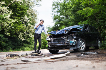 Wall Mural - Mature man standing by the car, making a phone call after a car accident.