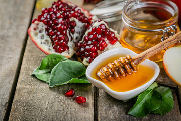 Rosh hashana jewish holiday concept - apples, honey, pomegranate