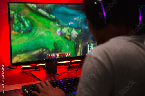 Asian Teenage Gamer Boy Playing Video Games On Computer In