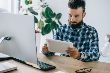 Wall Mural - handsome young man using tablet at workplace