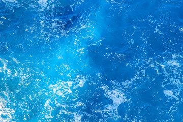 Aerial view of the clear blue sea surface on a bright sunny day.