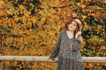 Outdoor portrait of beautiful woman enjoying autumn forest on a nice warm day