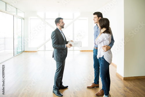 Fotografía Broker Discussing With Couple While Standing In New House