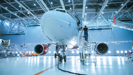brand new airplane standing in a aircraft maintenance hangar while aircraft maintenance engineer/ te