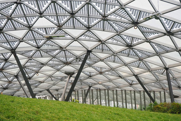 Architectural building elements. Glass roof, green lawn and metal frame parts.