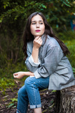 Model In A Gray Jacket Sitting On A Stump
