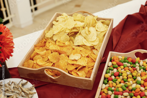 Salty Chips And Nuts On Wooden Desk On Table Wedding Reception