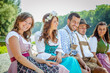 © karepa - Oktoberfest Freunde in Lederhosen und Dirndl trinken Bier an der Isar
