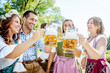 © karepa - Freunde Trinken Bier in der Bayerischer Tracht an der Isar