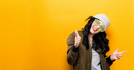 Wall Mural - Fashionable and happy woman in a bomber jacket on a golden yellow background