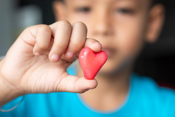 Candy red heart in hand a boy.