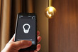 © andreysha74 - Smart Home: Man Controlling Lights With App On His Phone. electric concept.