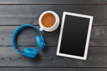 Digital tablet on wooden table in cafe with cup coffee