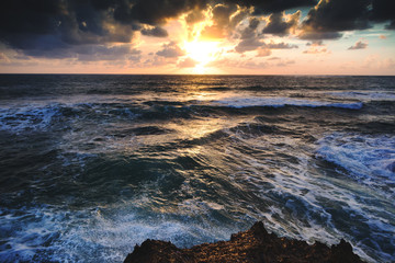 Wall Mural - Beautiful bright colorful stunning sea sunset, rays of the sun in the clouds dramatic sunset over the ocean