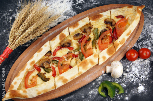 Fotografía The national Turkish pizza is called pide, next to vegetables and spikelets of w