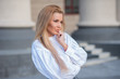 © Михаил Решетников - portrait of a blonde on a building background with columns. beautiful blonde in a white blouse smiling