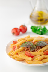 Wall Mural - Pasta Fettuccine Bolognese with tomato sauce and basil in white dish on the white background.