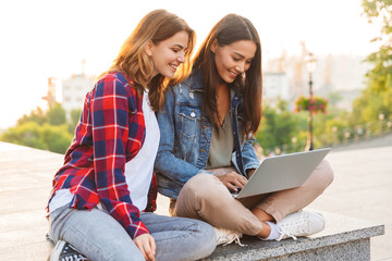 Canvas Print - Two pretty young girls friends sitting together