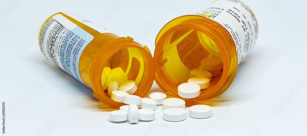 Two pain oill bottles with pills spilling out - obrazy, fototapety, plakaty 