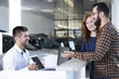 © Photographee.eu - Happy buyers talking with car dealer with tablet in the showroom
