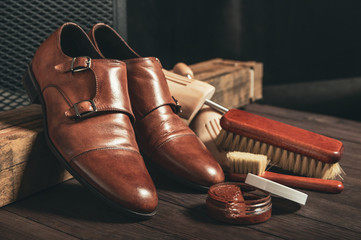 leather shoes and shoe polish equipment on a wooden composition