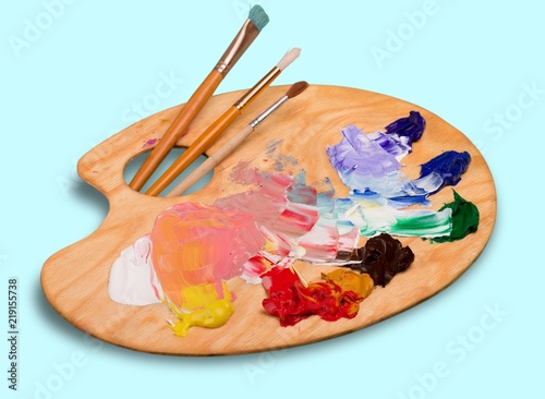 Cuadros en Lienzo Wooden art palette with blobs of paint and a brushes on white
