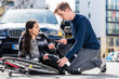 © Kzenon - Young man looking for the ambulance while calling the emergency services after hitting a female bicyclist in an accidental collision with his 4x4 car