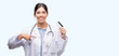 © Krakenimages.com - Young hispanic doctor woman holding credit card with surprise face pointing finger to himself