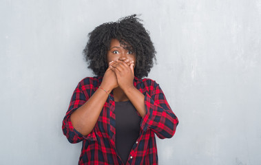 Canvas Print - Young african american hipster woman over grey grunge wall shocked covering mouth with hands for mistake. Secret concept.