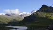Alpejski wysokogórski lodowcowy krajobraz z skalista górą na pierwszym planie.