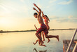 © BalanceFormCreative - Group of friends jumping into the lake from wooden pier.Having fun on summer day.