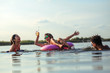 © BalanceFormCreative - Young friends swimming and having fun in the lake.Female sitting on air mattress drinks lemonade  and having fun with friends.