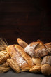 Composition of abundance of freshly baked loaves of bread and buns with ears of wheat