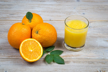 Orange juice and citrus fruits on rustic wooden table with copy space