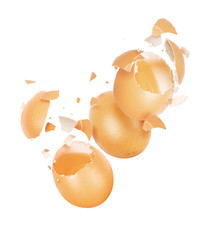 Broken chicken eggs in the air on a white background