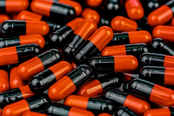 Sticker - Pile of orange-black capsule pills. Antibiotics resistance. Drug use with reasonable. Global healthcare concept. Antibiotics drug resistance. Antimicrobial capsule pills. Pharmaceutical industry.