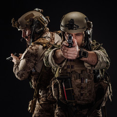 Wall Mural - soldiers or private military contractors holding rifle. Image on a black background. war, army, weapon, technology and people concept